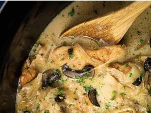 a spoon in crock pot creamy chicken marsala.
